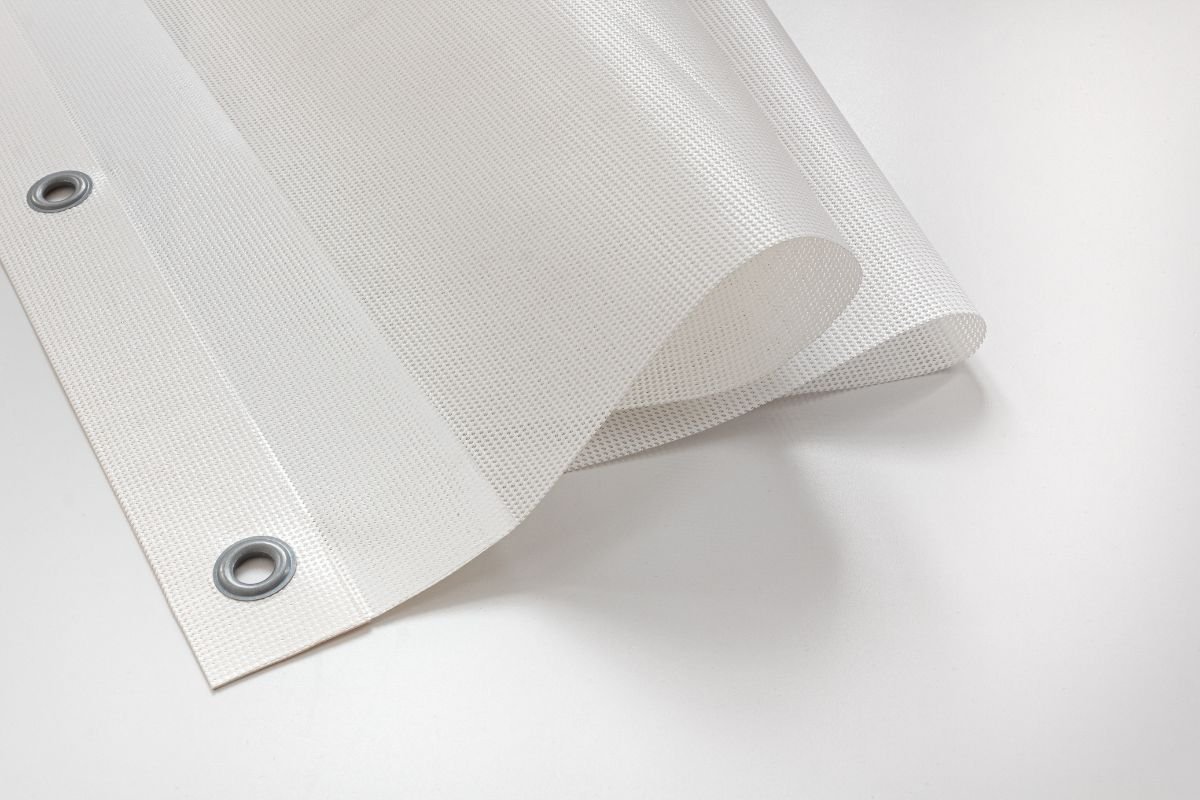 A large mesh banner covering the side of a building under construction. Mesh banner on a construction site