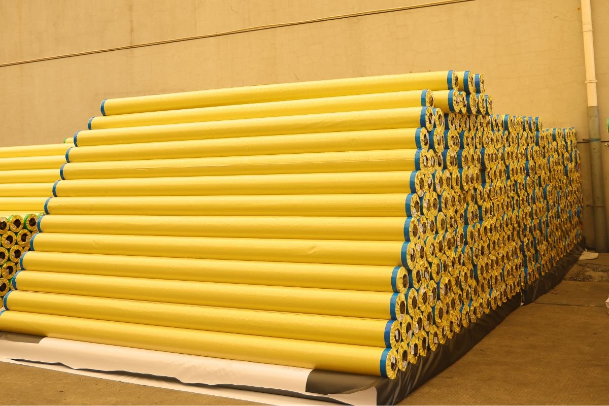 Various types of banner materials rolled up and stacked. Rolls of different banner materials in a warehouse