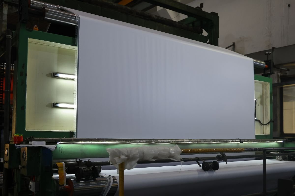 Illustrations of the direct coating process and the lamination process side-by-side. Comparison visual: coated banner vs. laminated banner production processes